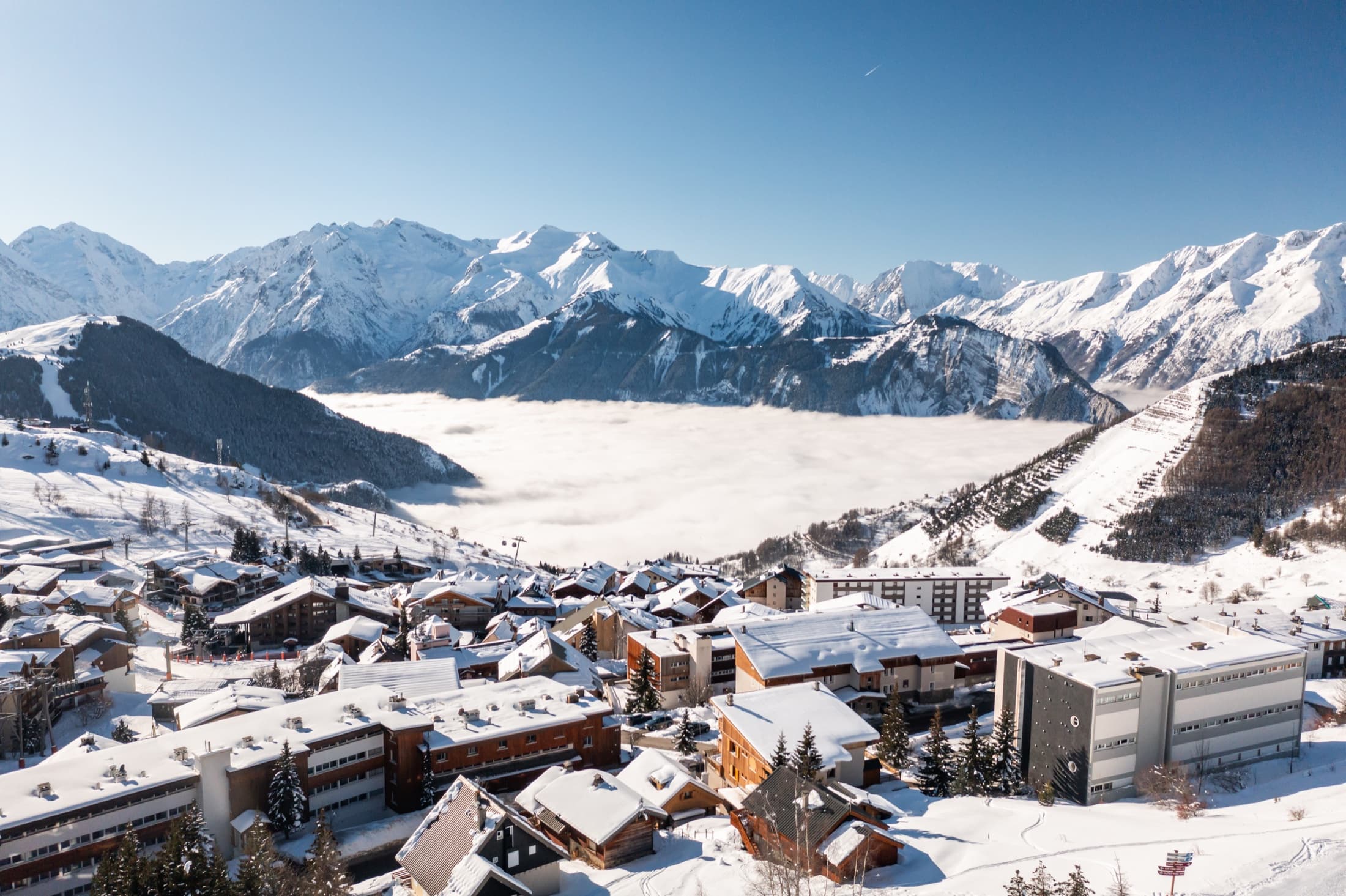 Panorama enneigé sur une station et une vallée de l’Oisans